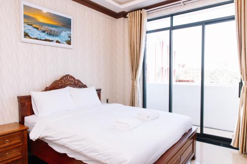 a bedroom with a bed and a large window at Hoa Hướng Dương Hotel in Phan Rang