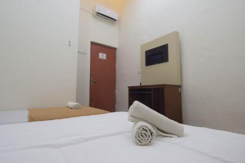 a hotel room with a bed and a tv at SIMPANG 7 RESIDENCE in Kudus