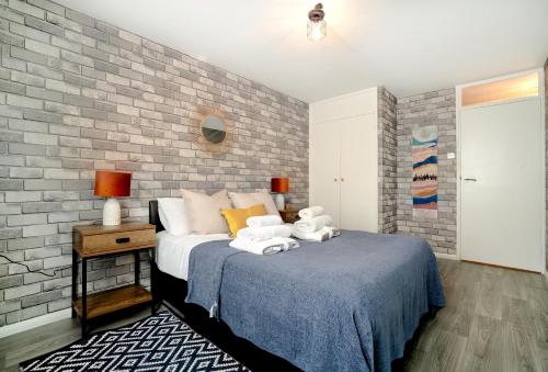 1 dormitorio con cama y pared de ladrillo en Sea View Kemptown Holiday Let, en Brighton & Hove