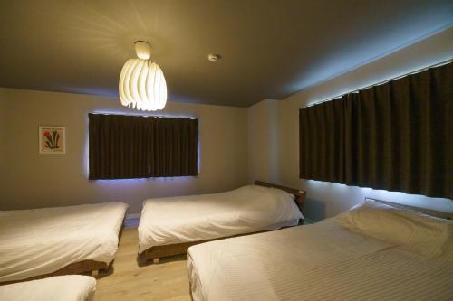 a bedroom with two beds and a chandelier at 自由自在OSU 202(UMI) in Nagoya