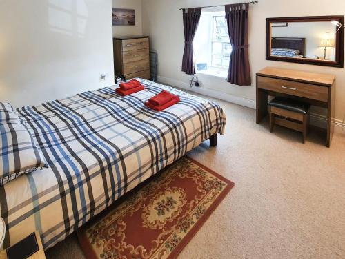 a bedroom with a bed and a desk and a mirror at Grooms Bothy in Bellingham