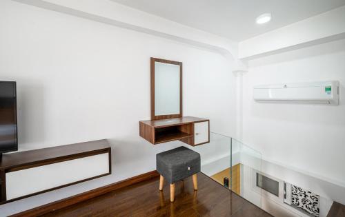 a mirror on a wall with a chair in a room at Cozrum Homes - Sonata Residence in Ho Chi Minh City