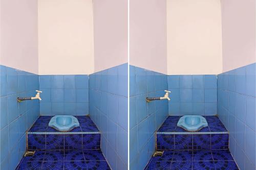 two blue toilets in a bathroom with blue tiles at SPOT ON 92421 City Kost Syariah in Pangkal Pinang