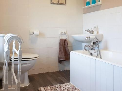 a bathroom with a toilet and a sink and a tub at Hendy in Llanfaelrhys