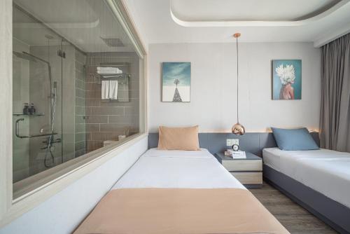 a bedroom with two beds and a shower at Cozrum Homes - Sonata Residence in Ho Chi Minh City