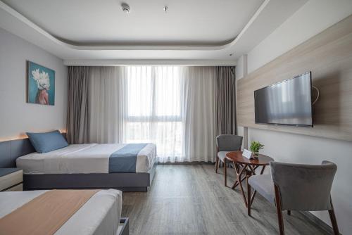 a hotel room with a bed and a flat screen tv at Cozrum Homes - Sonata Residence in Ho Chi Minh City
