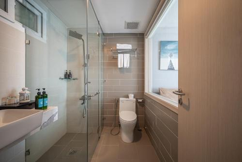 a bathroom with a toilet and a sink and a shower at Cozrum Homes - Sonata Residence in Ho Chi Minh City