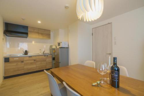 a bottle of wine sitting on a wooden table in a kitchen at 自由自在OSU 201(HANA) in Nagoya