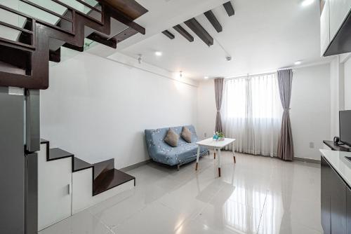 a living room with a blue couch and a table at Cozrum Homes - Sonata Residence in Ho Chi Minh City