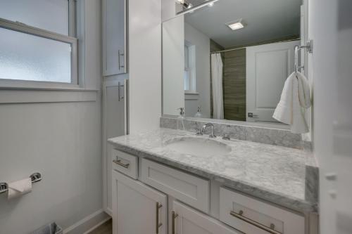 een witte badkamer met een wastafel en een spiegel bij Hillsboro Village Hideaway in Nashville