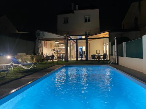a swimming pool at night with a house at Pension San Anton in Melide