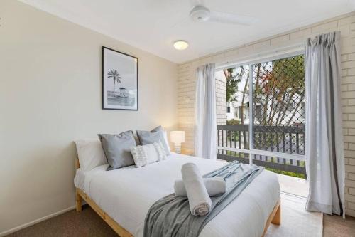 a bedroom with a bed and a large window at Beach Haven at Alex Heads in Alexandra Headland