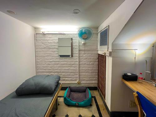 Habitación pequeña con cama y escritorio. en Rahee Bi Roambay - Backpacker Hostel, en Mysore