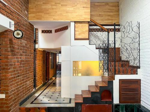 a staircase in a building with a brick wall at Rahees Bi Roambay - Backpacker Hostel in Mysore