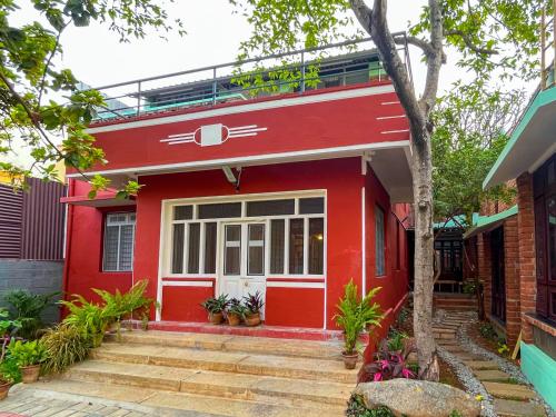 a red house with a red front door at Rahees Bi Roambay - Backpacker Hostel in Mysore