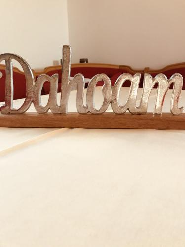 a wooden sign spelling out the wordonement on a bed at Ferienwohnung Wia Dahoam in Steingädele
