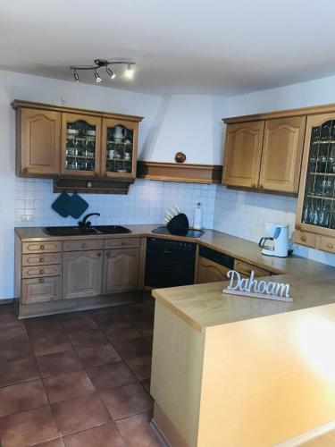 a kitchen with wooden cabinets and a counter top at Ferienwohnung Wia Dahoam in Steingädele