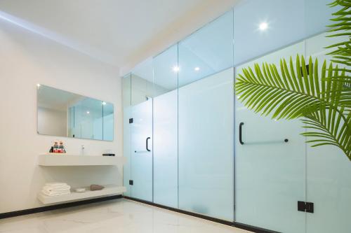 a bathroom with a glass shower and a sink at Deer Chenke seascape Surf B&B in Sanya