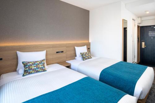 two beds in a hotel room with two at FLEXSTAY INN Shinurayasu in Urayasu