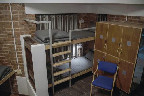 a room with a bunk bed and a chair at Rahees Bi Roambay - Backpacker Hostel in Mysore
