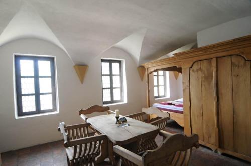 a dining room with a table and chairs and a bed at Penzion Hrad in Frýdek-Místek