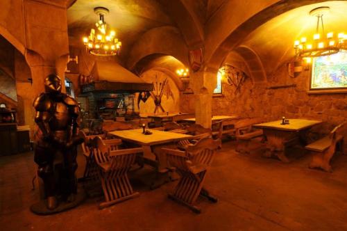 a statue of a man standing in a room with tables at Penzion Hrad in Frýdek-Místek