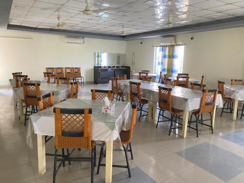 a dining room with tables and chairs with white table cloth at Hotel River View in Sylhet