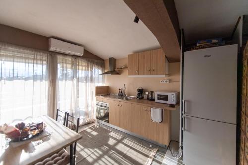 uma pequena cozinha com um frigorífico e uma mesa com uma mesa em HOUSE NEFELI em Témeni