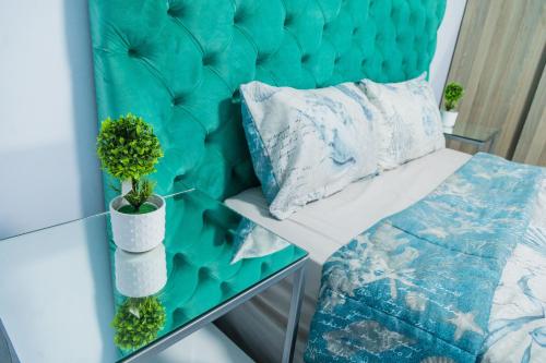 um quarto com uma cabeceira azul e um sofá com uma almofada em Blue Agave F2 em Lusaka