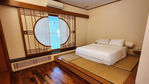 1 dormitorio con cama y ventana en Japanese Style Villa at Dago Bandung 4BR Soo Maison, en Bandung
