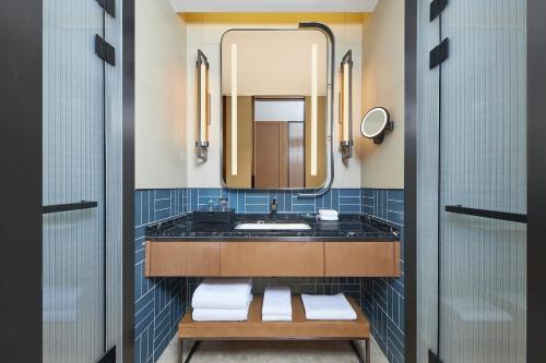 ein Bad mit einem Waschbecken und einem Spiegel in der Unterkunft Four Points by Sheraton Nanchang, Xihu in Nanchang