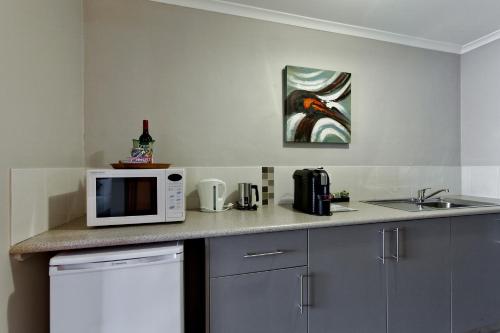 a kitchen counter with a microwave and a sink at Hume Country Motor Inn in Albury