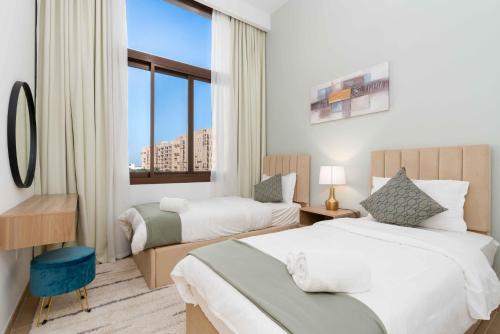 um quarto de hotel com duas camas e uma janela em Town Square em Dubai