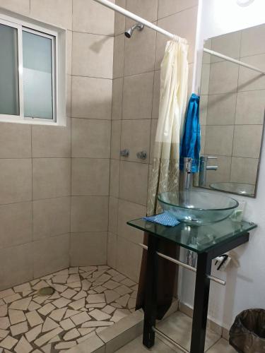 a bathroom with a glass sink and a shower at Twin Towers Tres Mares in Acapulco