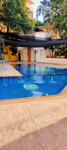 a swimming pool with blue water in front of a building at Twin Towers Tres Mares in Acapulco