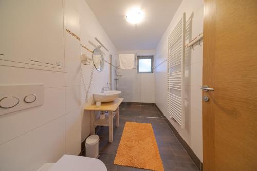 a white bathroom with a sink and a toilet at Appartement-Edelweiss in Altenmarkt im Pongau