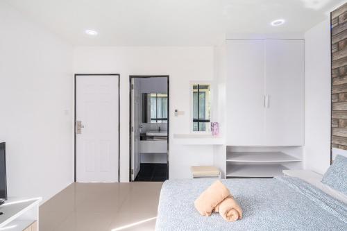 a bedroom with white walls and a bed with a pillow at AnB Loft 1 poolvilla 3BR/3bath in Ban Huai Yai