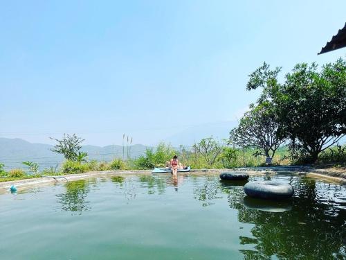 a man sitting on a raft in a body of water at Monsonkeang Camping view ม่อนสันเกี๋ยง in Mae Chaem