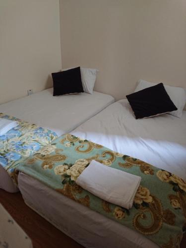 two beds with black pillows on them in a room at Butterworth Seaside view Family spacious in Butterworth