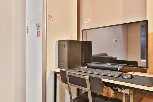 a desk with a computer and a keyboard on it at Gracias Hotel Gimhae in Gimhae