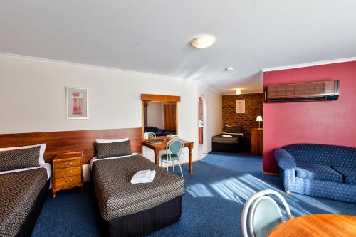 a hotel room with a couch and a table at Hume Country Motor Inn in Albury