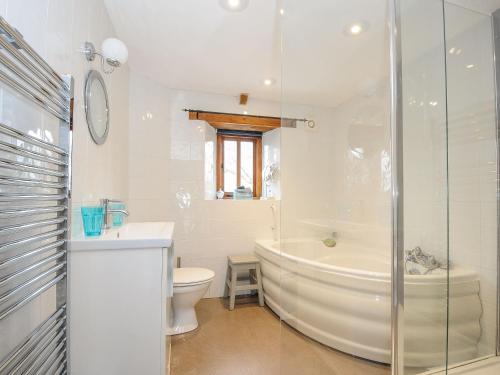 ein Badezimmer mit einer Badewanne, einem WC und einem Waschbecken in der Unterkunft Swallow Barn in Saint Kew