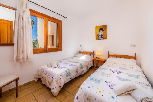 two twin beds in a room with a window at Casa Fina in Felanitx