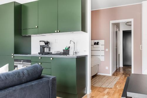 a kitchen with green cabinets and a couch at Studio Living in Karlskrona