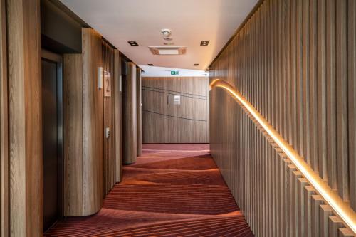 einen Flur mit Holzwänden und Treppen in einem Gebäude in der Unterkunft Flow Hotel & Conference in Inárcs