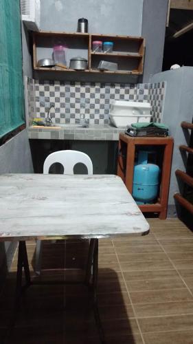 CatangnanにあるBearby's Homestay Siargaoのカウンター付きキッチン(テーブル、椅子付)