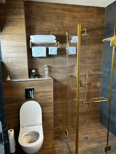 a bathroom with a toilet and a glass shower at מלון בוטיק H34 in Nahariyya