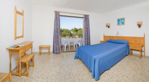 a bedroom with a blue bed and a table and chairs at Hotel Bahia Playa in San Antonio Bay