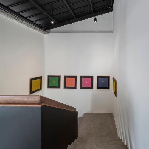 a room with paintings on a white wall at Lilit Bang Lumphu Hotel in Bangkok