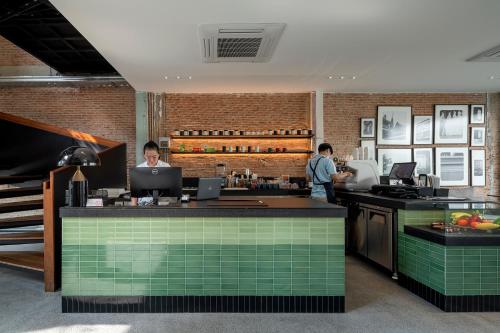 two men standing at a bar in a restaurant at Lilit Bang Lumphu Hotel in Bangkok
